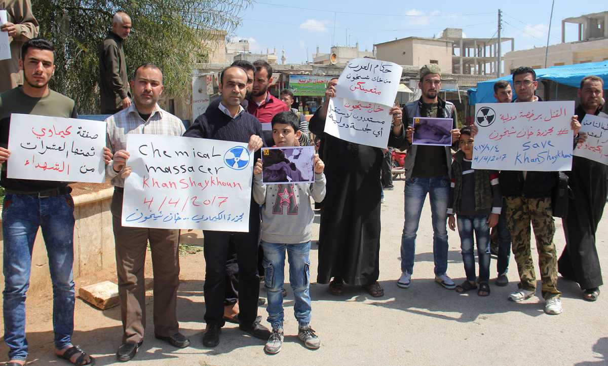 Syrian residents of Khan Sheikhoun hold placards and pictures on April 7, during a protest condemning a chemical weapons attack on their town two days earlier. Credit: Omar Haj Kadour/AFP/Getty Images