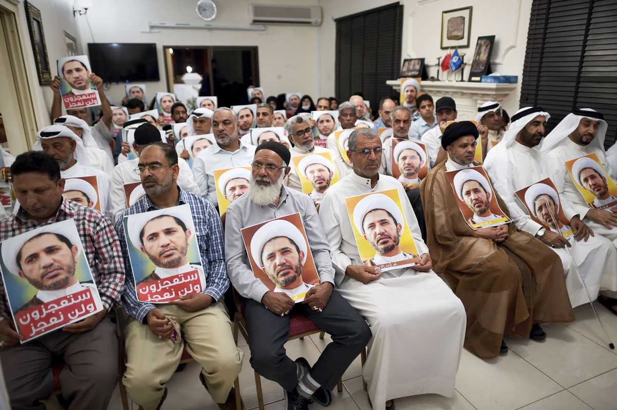 Bahraini men hold placards bearing the portrait of Sheikh Ali Salman, head of the Shiite opposition movement Al-Wefaq, during a protest on May 29.  Credit: Mohammed Al-Shaikh/AFP/Getty Images