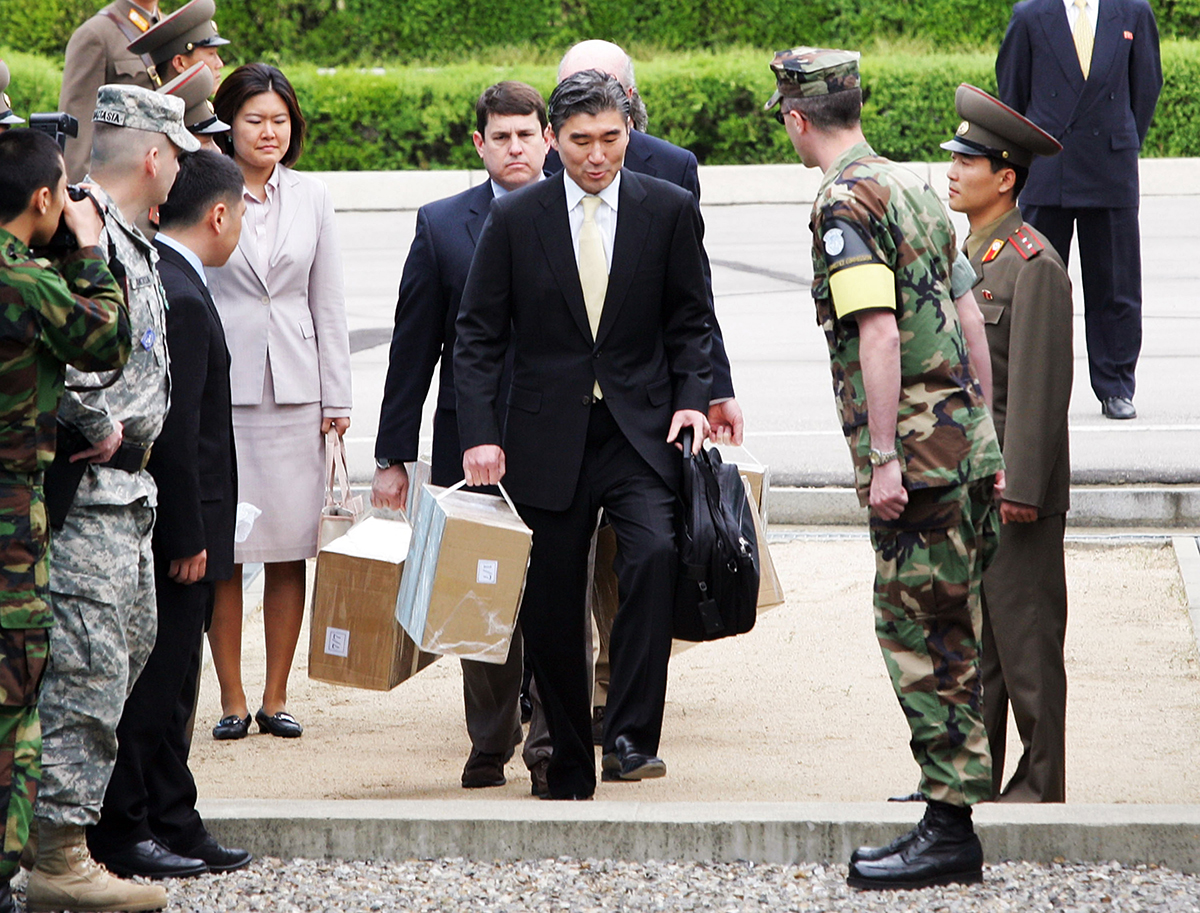 A U.S. delegation led by State Department official Sung Kim crosses the military demarcation line between North and South Korea May 10, 2008, carrying boxes of North Korean documents. North Korea had declared its separated plutonium inventory and provided 18,000 pages of records on the operation of its production reactor and reprocessing facility to permit verification in response to a U.S. proposal for “full access to records.” (Photo credit: Chung Sung-Jun/Getty Images)
