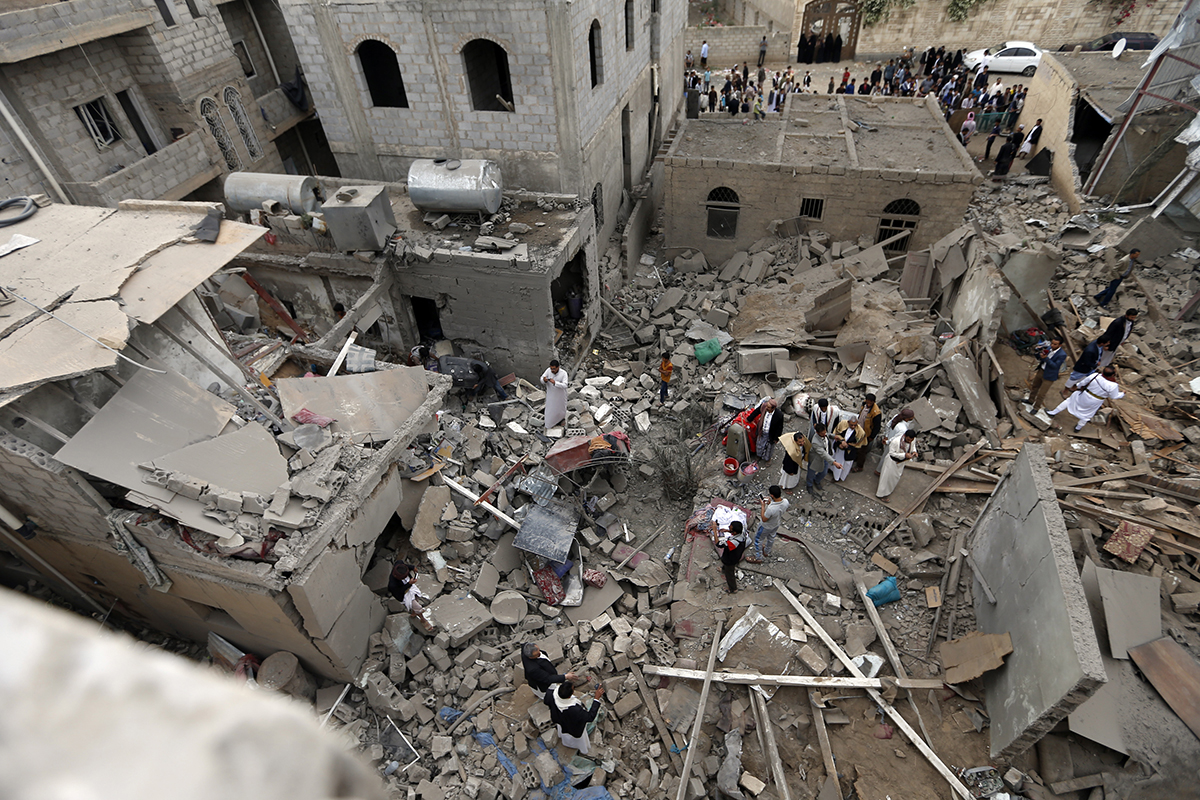 Yemenis stand on the rubble of houses near the presidential palace in Sanaa that were destroyed in a June 9 air strike attributed to the Saudi-led coalition. Four civilians, including two teenagers, reportedly died in the strike. (Photo credit: AFP/Getty Images)