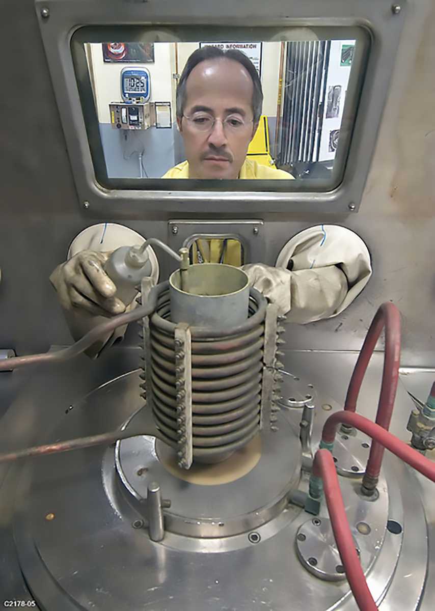 A technician at Los Alamos National Laboratory is shown working on a plutonium “pit,” a key component in nuclear warheads, in a 2011 photograph. The pit, when compressed by chemical explosives, initiates a weapon’s nuclear chain reaction. (Photo credit: Los Alamos National Laboratory)