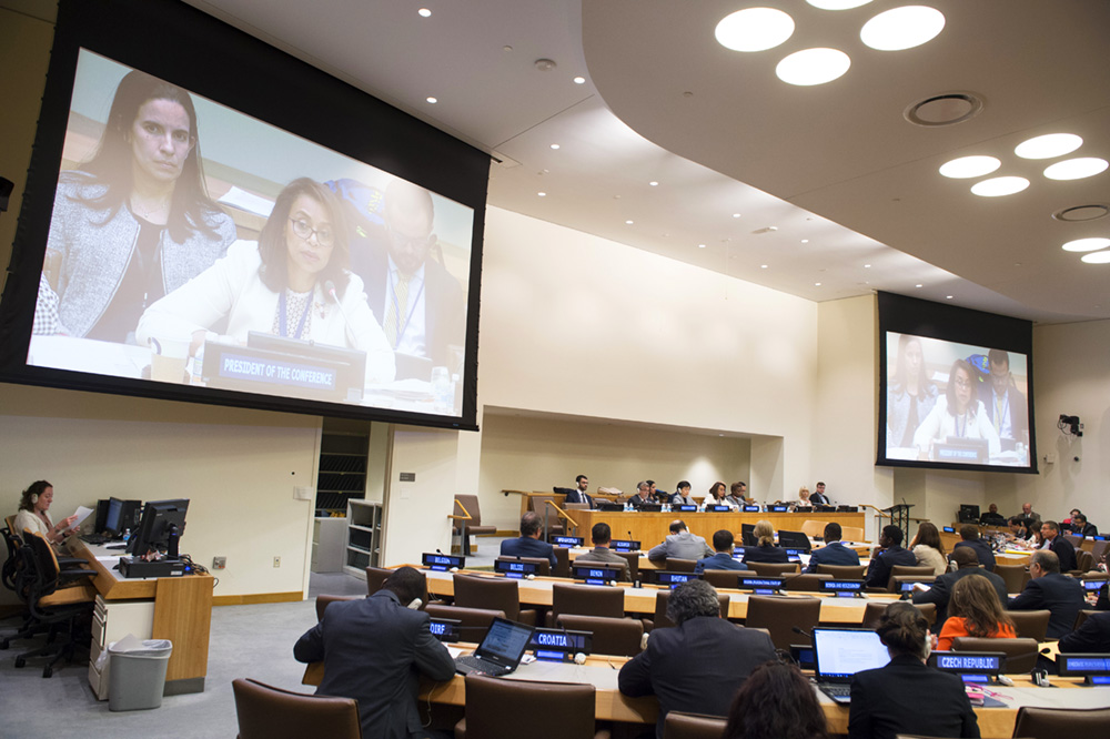 Ambasssador Elayne Whyte Gómez (shown on screens), permanent representative of Costa Rica to the UN Office at Geneva and president of the negotiating conference, addresses the July 6 session. (Photo credit: UN Photo/Eskinder Debebe) 