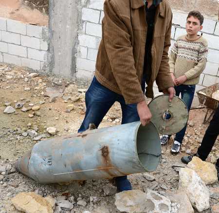 A Syrian man shows a cluster bomb, that releases or ejects smaller submunitions, in the northern Syrian town of Taftanaz, in the Idlib province, on November 9, 2012. (Photo credit: Philippe Desmazes/AFP/Getty Images)