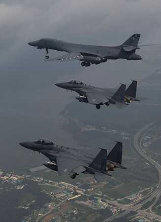 A photo released July 30 by the South Korean Defense Ministry shows a U.S. Air Force B-1B  bomber (top) accompanied by South Korean F-15 fighter jets over the Korean peninsula in response to North Korea's missile tests.  (Photo credit: South Korean Defense Ministry via Getty Images)
