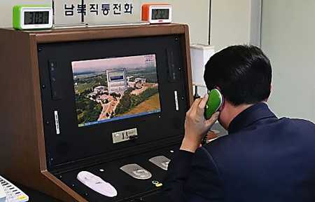 In photo provided by the South Korean Unification Ministry, a South Korean official checks the direct communications hotline being re-activated to talk with the North Korean side at the border village of Panmunjom on January 3. (Photo: South Korean Unification Ministry via Getty Images)