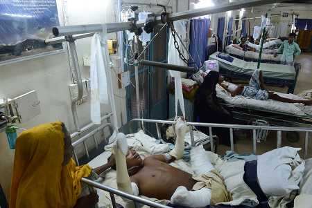 Rohingya refugee Rashida Begum stands next to her son in a Bangladeshi hospital as he is treated September 30, 2017, after being injured by a landmine while fleeing Myanmar. (Photo: MUNIR UZ ZAMAN/AFP/Getty Images)