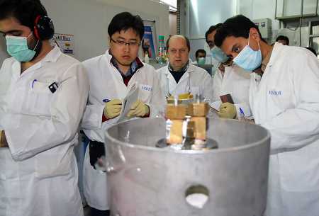 International Atomic Energy Agency inspectors and Iranian technicians disconnect the connections between the twin uranium-enrichment cascades at the Natanz facility on January 20, 2014, as Iran halted production of 20 percent enriched uranium under terms of a deal with world powers to curtail capabilities that could be used to produce nuclear weapons. (Photo: KAZEM GHANE/AFP/Getty Images)