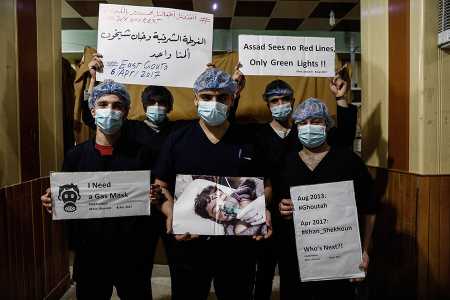 Medical staff at Damascus Countryside Specialised Hospital hold placards April 6, 2017 condemning a suspected chemical weapons attack on the Syrian town of Khan Sheikhoun. (Photo: SAMEER AL-DOUMY/AFP/Getty Images)