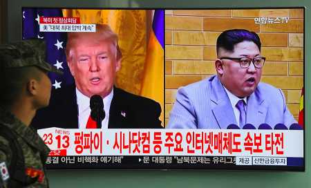 A South Korean soldier walks past a television screen showing pictures of U.S. President Donald Trump and North Korean leader Kim Jong Un, at a railway station in Seoul on March 9, 2018. Trump agreed on March 8 to a historic first meeting with the North Korean leader. (Photo: JUNG YEON-JE/AFP/Getty Images)