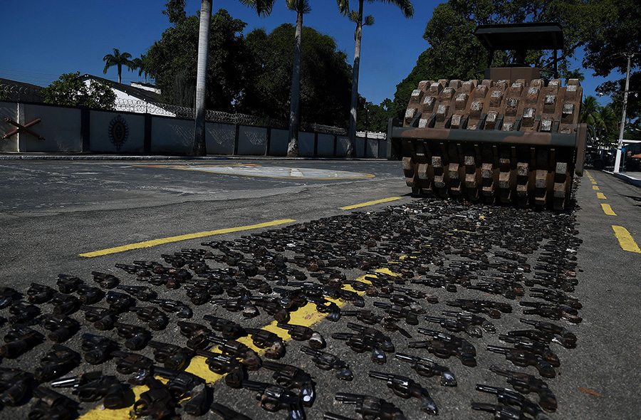 Guns seized from criminals by the Brazilian armed forces are crushed June 20 at a military base in Rio de Janeiro. The weapons were part of a large cache that had been stored as evidence. (Photo: Carl De Souza/AFP/Getty Images)