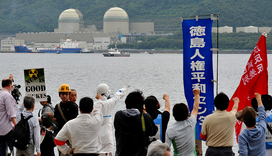 Protesters demonstrate against the arrival of a vessel loaded with mixed-oxide (MOX) nuclear fuel from France for the Kansai Electric Power Co.'s Takahama nuclear plant at a Japanese port on June 27, 2013. The cargo of MOX fuel, a blend of plutonium and uranium, was the first such nuclear fuel to arrive in Japan since the atomic disaster at Fukushima, which was sparked by the earthquake and tsunami of March 2011. (Photo: Kazuhiro Nogi/AFP/Getty Images)