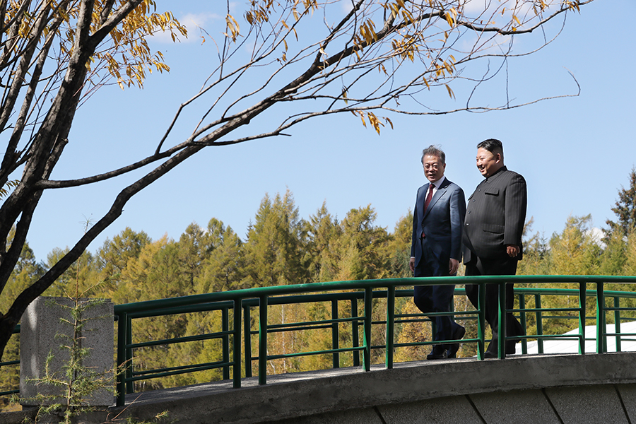 North Korean leader Kim Jong Un (R) and South Korean President Moon Jae-in walk together during a visit to Samjiyon guesthouse on September 20, during their summit held in Pyongyang. (Photo Pyeongyang Press Corps/Pool/Getty Images)