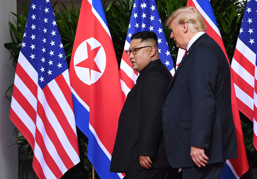 U.S. President Donald Trump walks with North Korean leader Kim Jong Un at the start of their historic summit at the Capella Hotel on Sentosa Island in Singapore on June 12. (Photo by Saul Loeb/AFP/Getty Images)