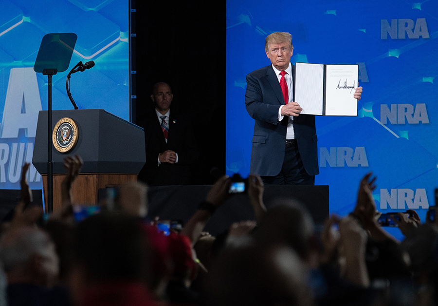 Speaking to the National Rifle Association on April 26, President Donald Trump displays an order he signed during the speech for the United States to reject the Arms Trade Treaty. (Photo Saul Loeb/AFP/Getty Images)