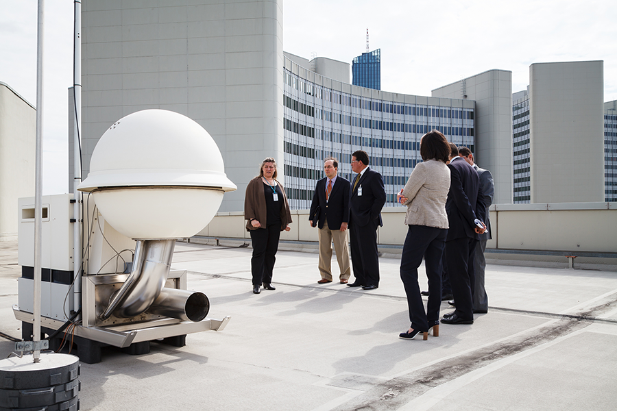 Officials examine a radionuclide detector stationed on the roof of the Vienna International Centre, home of CTBTO headquarters.  Russia has deployed seven such detectors on its territory as part of the CTBTO's monitoring system, but some stopped transmitting information after a Russian weapons accident on Aug. 8. (Photo: CTBTO)