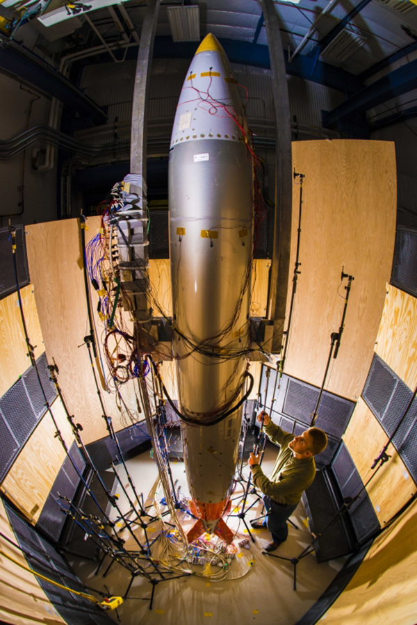 A Sandia National Laboratories engineer adjusts a microphone for an acoustic test on a B61 gravity bomb. (Photo: NNSA)