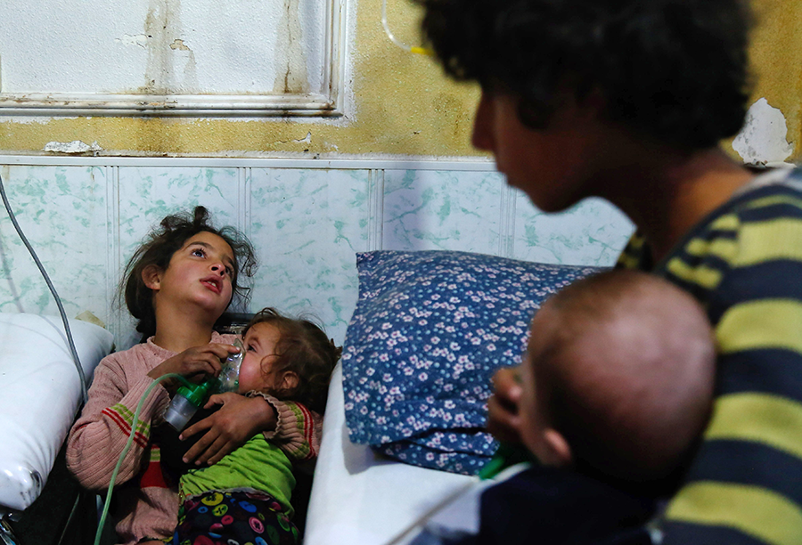 A Syrian girl holds an oxygen mask over the face of an infant at a makeshift hospital following a reported gas attack in Douma on the outskirts of the capital Damascus in 2018.  (Photo: Hasan Mohamed/AFP/Getty Images)