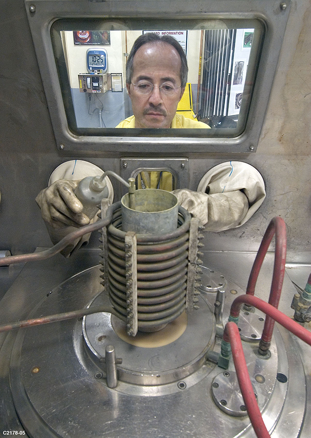 A technician at Los Alamos National Laboratory manipulates plutonium as part of the U.S. Stockpile Stewardship Program in 2005. The laboratory has sought a major role in producing new plutonium pits despite an uneven safety record.  (Photo: U.S. Energy Department)