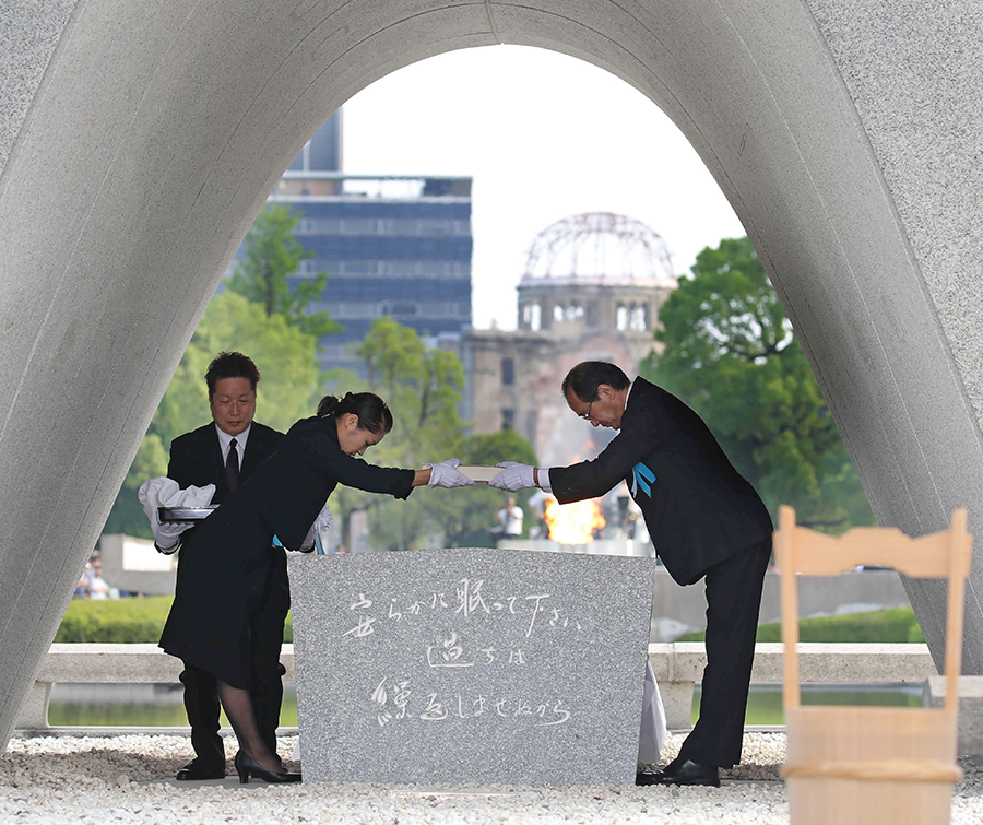 In a 2016 ceremony, Hiroshima Mayor Kazumi Matsui (right) offers new names to add to the list of the atomic bomb deaths that is kept at the Memorial Cenotaph in Hiroshima. More than 290,000 names have been inscribed inside the memorial's stone vault. (Photo: AFP/Getty Images)