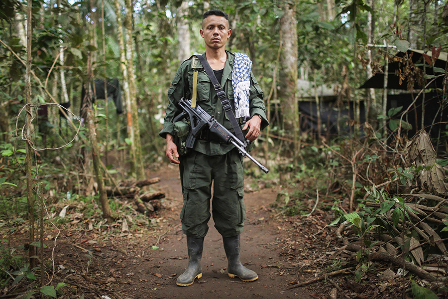 A Colombian rebel stands by as the Fuerzas Armadas Revolucionares de Colombia-Ejercito del Pueblo ratifies a peace accord with the government on Sept. 23, 2016. The two sides agreed to undertake joint landmine clearance activities during the peace negotiations, and the final agreement included measures for removing explosives that endangered civilian communities. (Photo: by Mario Tama/Getty Images)
