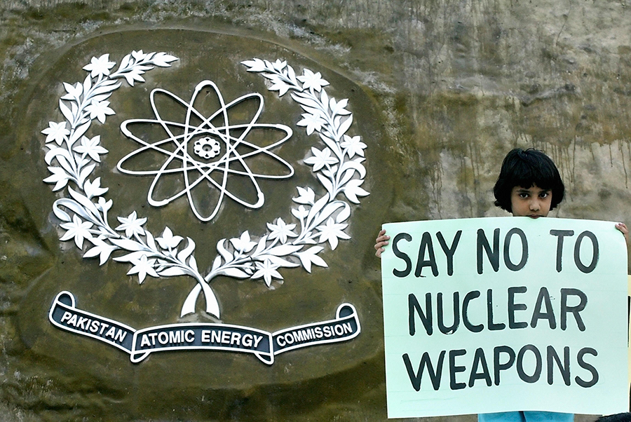 A Pakistani girl displays a placard as she stands in front of a replica of the Chagai mountain, where Pakistan detonated its first nuclear weapon test explosion on May 28, 1998, during a demonstration organized by the Citizen Peace Committee, a non government organization, in Islamabad, May 28, 2005. (Photo: Jewel Samad/AFP/Getty Images)