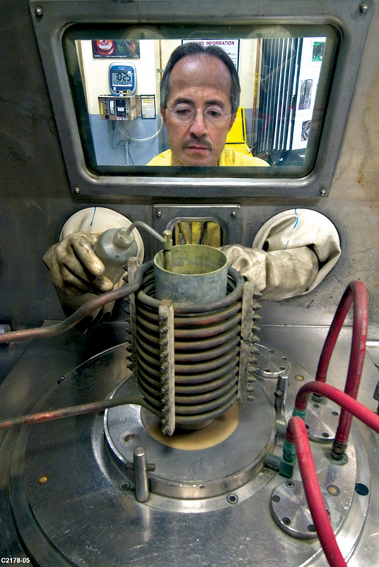 A technician at Los Alamos National Laboratory in New Mexico manipulates plutonium as part of the U.S. Stockpile Stewardship Program in 2005. Current plans call for expanding the production of plutonium pits at both Los Alamos and at the Savannah RIver Site in South Carolina. (Photo: U.S. Energy Department)