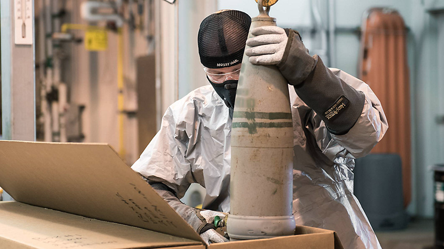 A munitions handler guides a 155mm projectile containing mustard agent into a box to begin the destruction process at the Blue Grass Chemical Agent-Destruction Pilot Plant in Blue Grass, Kentucky. The last mustard-agent projectile was processed on Sept. 4. (U.S. Department of Defense photo)