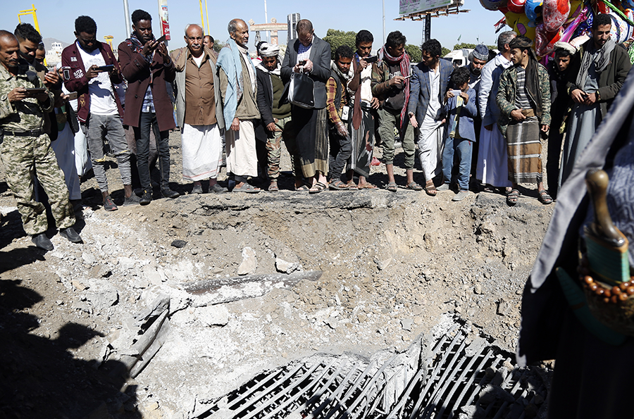 Yemenis inspect the scene of an aerial attack, carried out by a jet aircraft of the coalition led by Saudi Arabia, on Dec. 23 in Sana'a, Yemen.  (Photo by Mohammed Hamoud/Getty Images)
