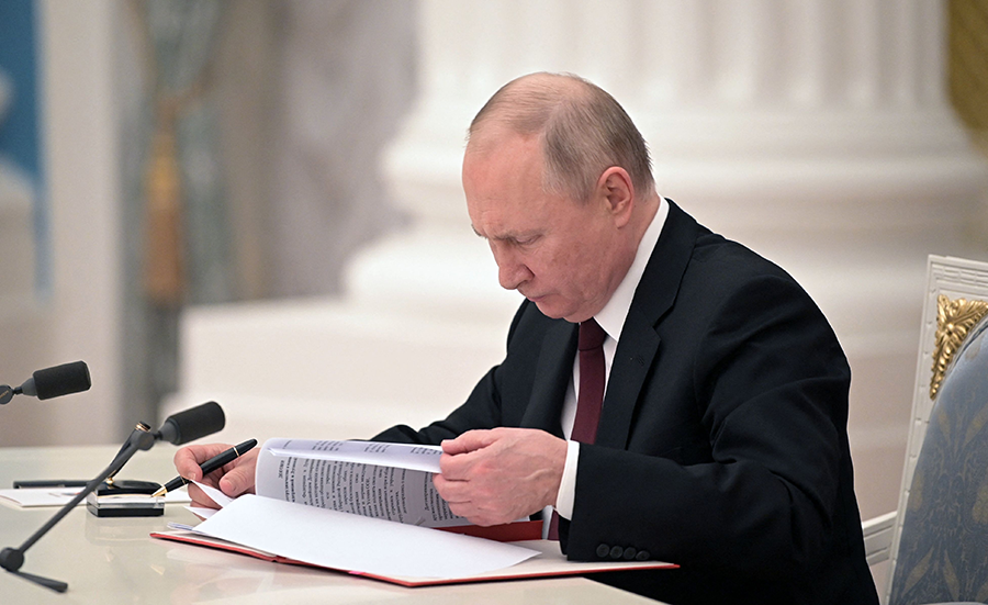 Russian President Vladimir Putin signs documents, including a decree recognizing the independence of two Russian-backed breakaway regions in eastern Ukraine, at the Kremlin in Moscow on February 21. (Photo by Alexey Nikolsky/Sputnik/AFP via Getty Images)