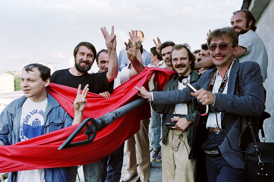 Ukranians flash the v-sign after taking down the Soviet red flag from the Ukrainian Communist Party headquarters on August 25, 1991 in Kyiv. (Photo by Anatoly Supinski/AFP via Getty Images)