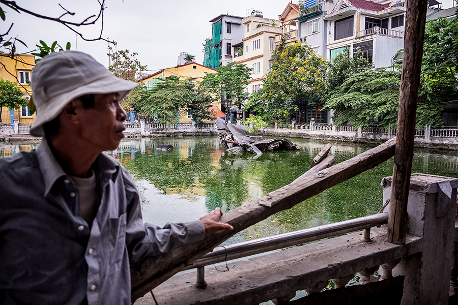 A Vietnamese man stands in front of the B-52 crash site in Huu Tiep Lake in 2016 in Hanoi, Vietnam. The bomber's wreckage is a legacy of the Vietnam War. (Photo by Linh Pham/Getty Images)