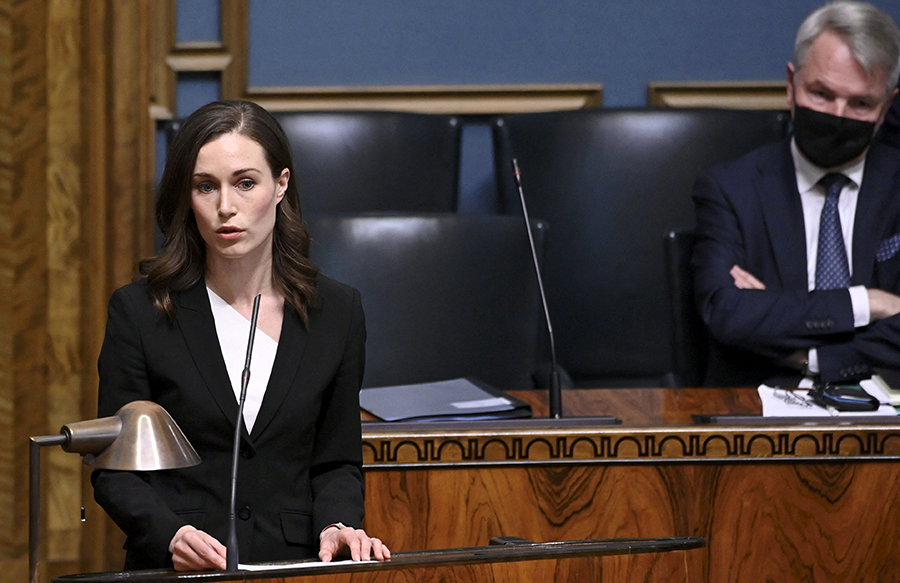 Finnish Prime Minister Sanna Marin (L) speaks while Foreign Minister Pekka Haavisto listens on April 20 as the Finnish parliament began debating whether to seek NATO membership. The Russian invasion of Ukraine sparked a surge in political support for joining the bloc. (Photo by Heikki Saukkomaa/Lehtikuva/AFP via Getty Images)