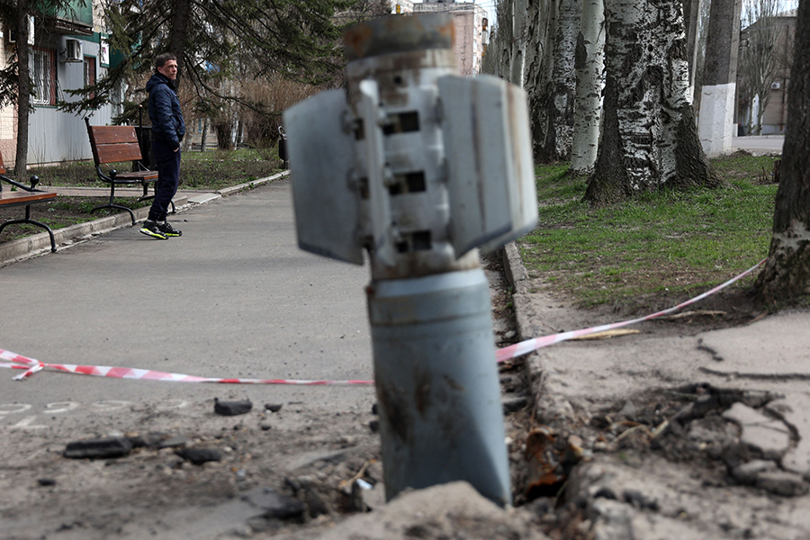 After shelling in Lysychansk during the Russian war in Ukraine in April, a man walks past an unexploded tail section of a 300mm rocket which appear to contain cluster bombs launched from a BM-30 Smerch multiple rocket launcher. (Photo by Anatolii Stepanov/AFP via Getty Images)