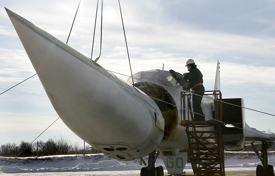 A worker on a Ukrainian military base in 2006 cuts the nose off the last of Ukraine's Tupolev-22M3 bombers, also known as the "Backfire", a Soviet-made nuclear-capable strategic aircraft. A total of 60 aircraft were destroyed as part of an agreement under which Ukraine gave up nuclear weapons on its territory to Russia in return for security assurances that have now been violated. (Photo by Sergei Supinsky/AFP via Getty Images)