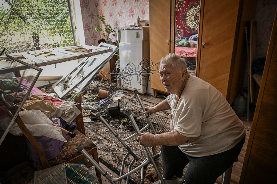 Russia's destruction of Ukrainian cities is driving home the devastating impact of explosive weapons on populated areas. In this photo from June, an elderly woman sits inside her damaged house in the eastern Ukrainian region of Donbas after a missile strike. (Photo by Aris Messinis/AFP via Getty Images)