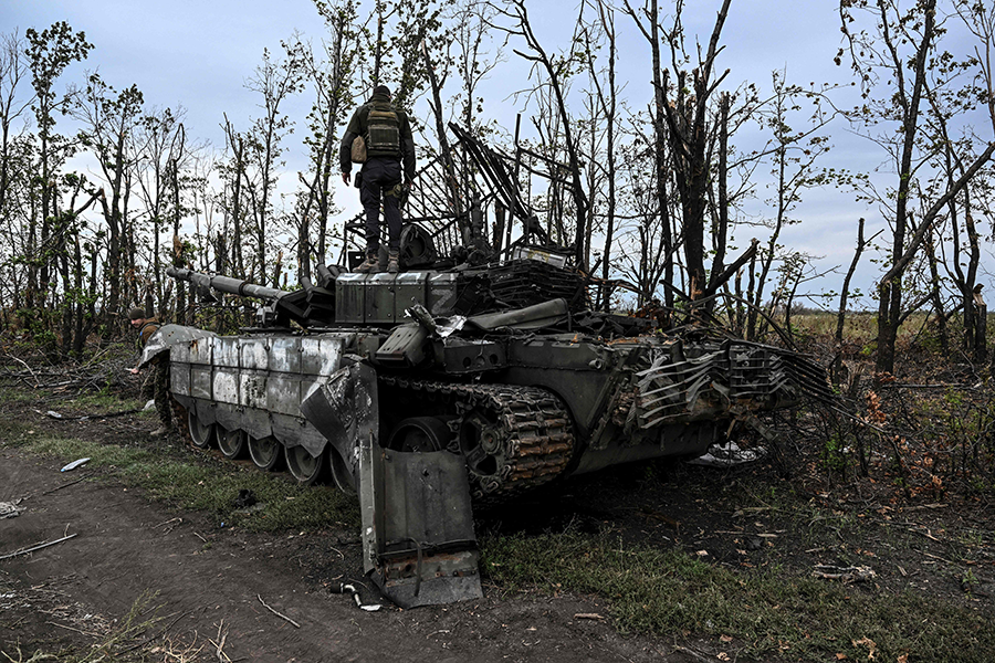 A Ukranian soldier stands atop an abandoned Russian tank near a village on the outskirts of Izyum in the Kharkiv Region of eastern Ukraine on Sept. 11. The Russian invasion has raised new questions about the potential spread of nuclear weapons.  (Photo by Juan Barreto/AFP via Getty Images)
