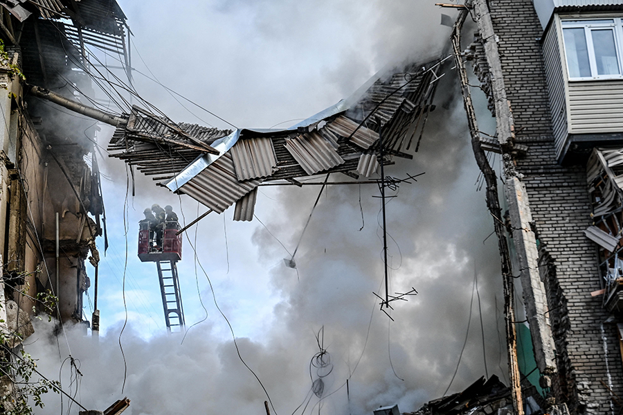 Ukrainian firefighters work to put out a fire after a strike in Zaporizhzhia on October 6, amid the Russian war on Ukraine. One day earlier, Russia laid formal claim to the nuclear power plant in Zaporizhzhia, which it has occupied militarily since early March. (Photo by Marina Moiseyenko / AFP via Getty Images)