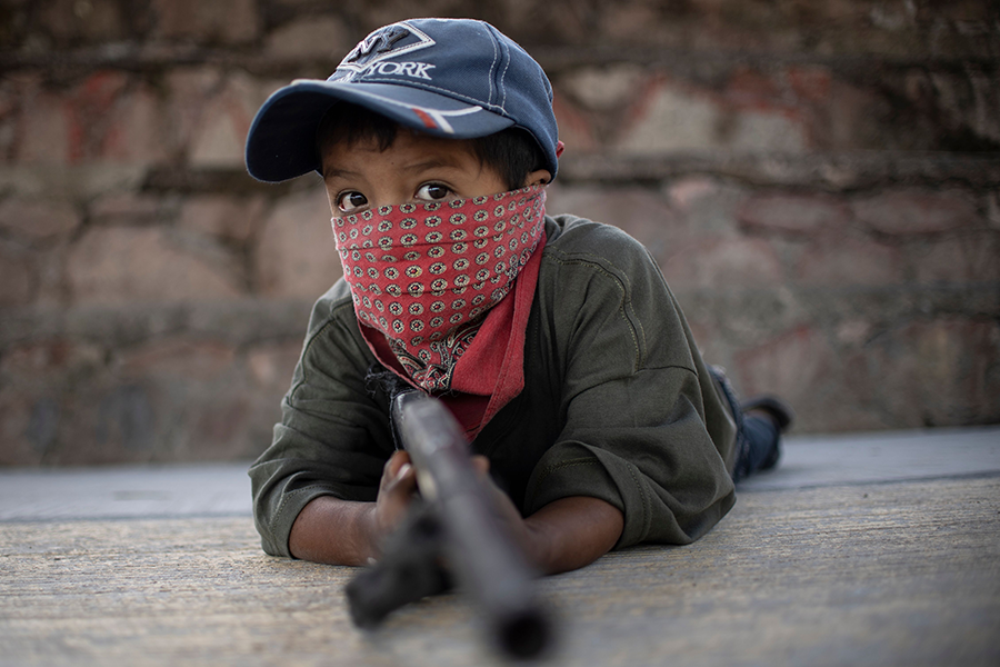 A boy holds a makeshift gun as a community police force in Mexico in 2020 teaches a group of children how to protect themselves from area drug gangs. Mexico is suing to stop the flow of guns from U.S. manufacturers and dealers into Mexico. (Photo by Pedro Pardo/AFP via Getty Images)