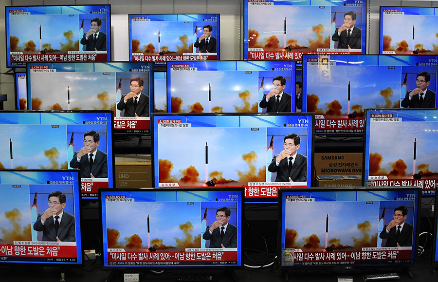 Television screens, using file footage, show a news report about the North Korean missile launch on November 3. The North’s advancing nuclear weapons and missile programs are the major source of tension on the Korean peninsula.  (Photo by JUNG YEON-JE/AFP via Getty Images)