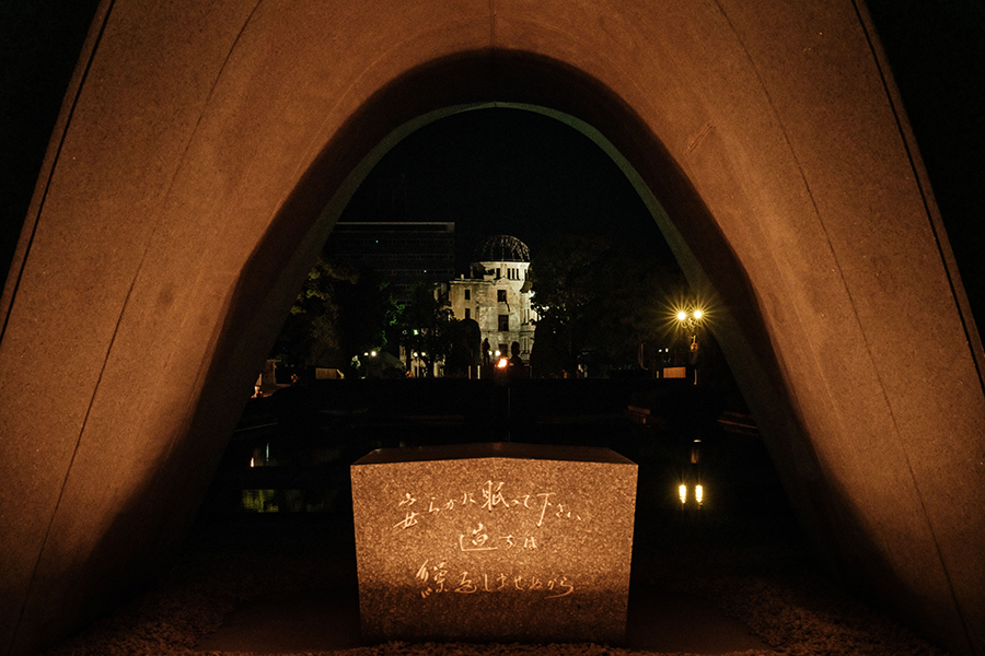 In this photo taken on August 6, 2021, the Hiroshima Prefectural Industrial Promotion Hall, as it was known before 1945, and now called the Atomic Bomb Dome, is seen through the cenotaph at the Peace Memorial Park in Hiroshima as the city marks the 76th anniversary of the world's first atomic bomb attack. (Photo by YASUYOSHI CHIBA/AFP via Getty Images)