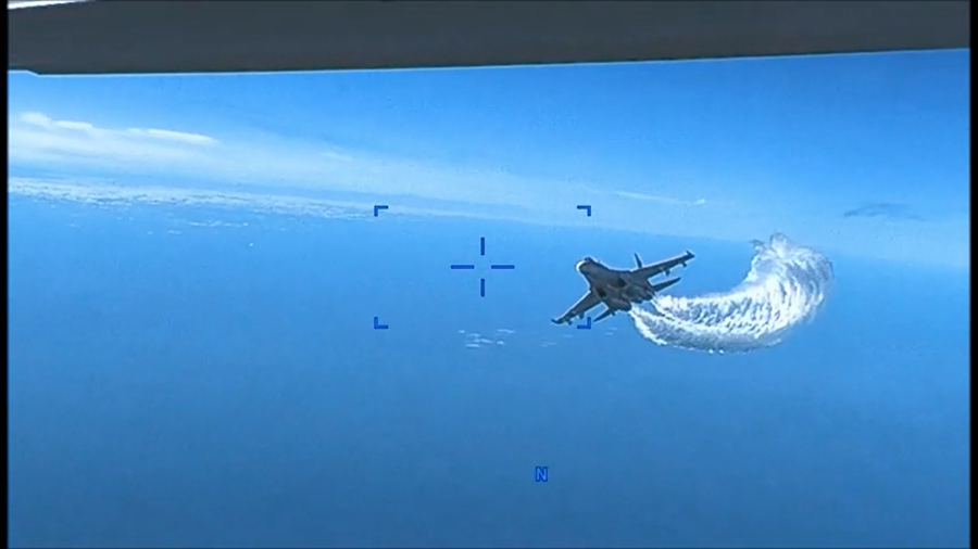 A photo captured from a video shows a U.S. drone being harassed by a Russian Su-27 fighter jet over the Black Sea on March 14. (Photo by U.S. European Command/Anadolu Agency via Getty Images)