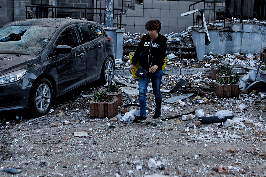 A woman with a bag walks through the rubble around a residential building in Kyiv, which was shelled on May 30. The Russian war on Ukraine is one factor causing Japan to rethink its defense needs. (Photo by Yan Dobronosov/Global Images Ukraine via Getty Images)