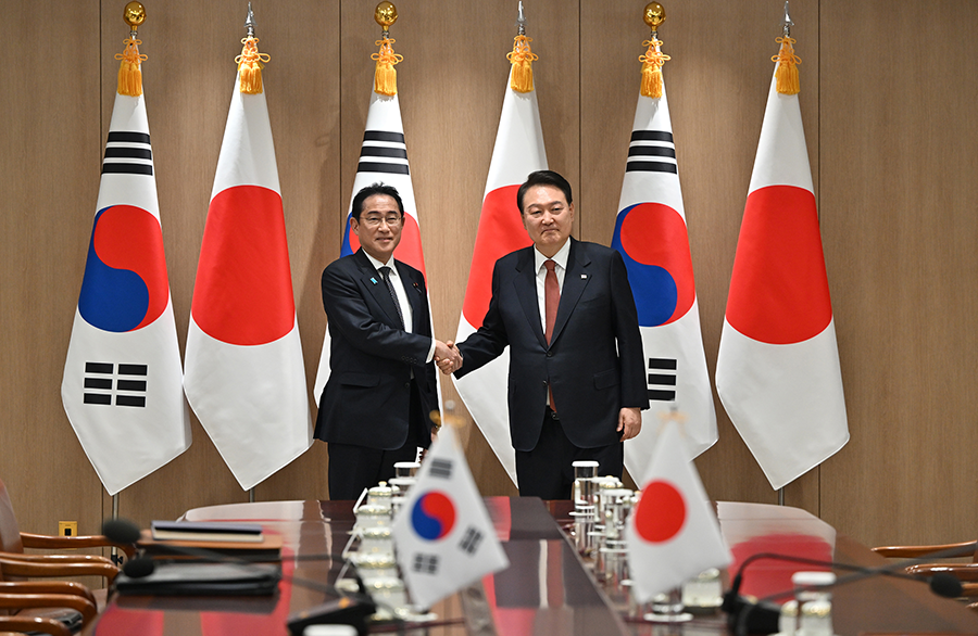 South Korean President Yoon Suk Yeol (R) shakes hands with Japanese Prime Minister Fumio Kishida during their meeting at the presidential office in Seoul on May 7, ahead of the Group of Seven summit in Hiroshima. (Photo by Jung Yeon-Je/Pool/Getty Images)