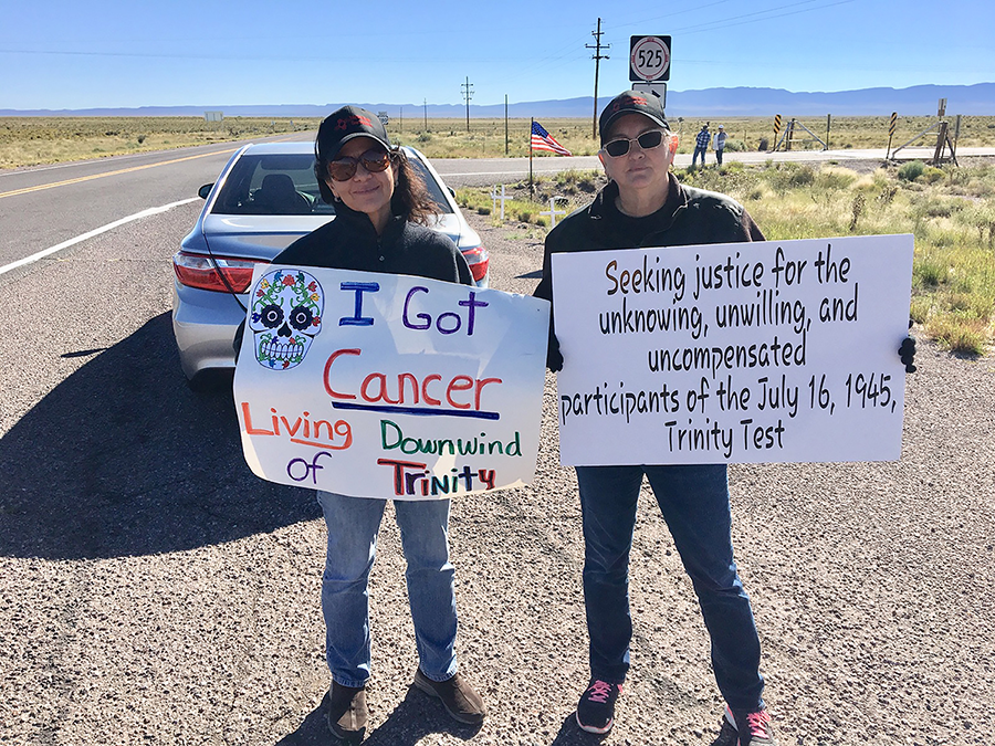 Tina Cordova (L) and Laura Greenwood of the Tularosa Basin Downwinders Consortium demonstrate to call attention to the legacy of the U.S. nuclear testing program and urge federal medical and other compensation for those still suffering the disastrous effects of those tests. (Photo courtesy of the Tularosa Basin Downwinders Consortium)