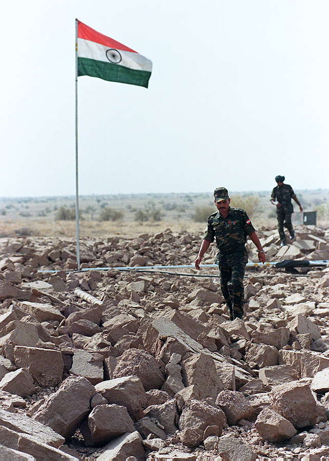 Indian soldiers in 1998 patrol shattered ground along the edge of the crater at the Pokhran Test Range where on May 11 and May 13 of that year the Indian government conducted five underground nuclear tests. (Photo by John MacDougall/AFP via Getty Images)