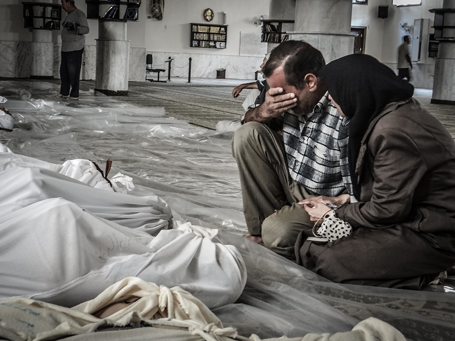 A mother and father weep over the body of a child who was killed in a suspected chemical weapons attack on the Damascus suburb of Ghouta, Syria, on August 21, 2013. (Photo by NurPhoto/Corbis via Getty Images)