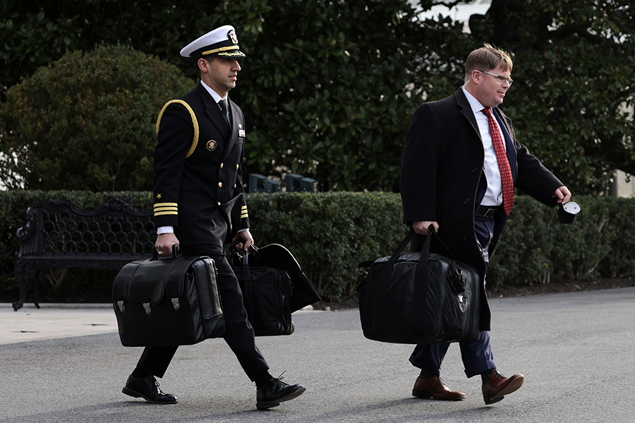 A military aide (L) carries the “nuclear football,” which contains launch codes for nuclear weapons, while departing the White House with U.S. President Joe Biden as he heads to Europe for a NATO meeting in 2022. (Photo by Alex Wong/Getty Images)