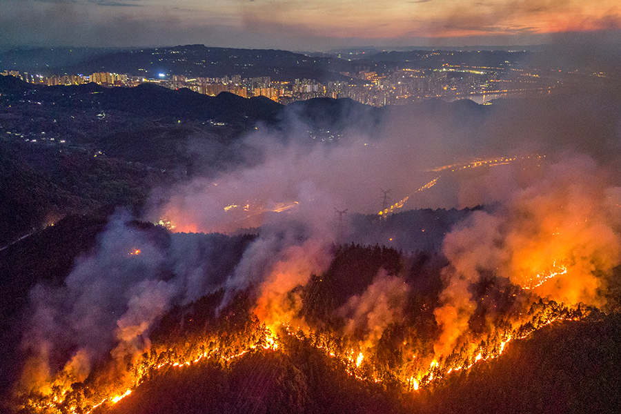 Smoke and flames rise from a mountain during a wildfire in Chongqing, China in 2022. Every nuclear- and non-nuclear-weapon state will confront the impacts of climate change in the years to come. (Photo by VCG/VCG via Getty Images)
