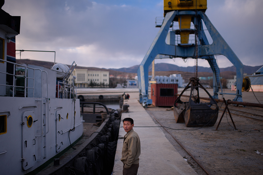 A worker stands before a boat in Najin, a port city in North Korea near the border with Russia. The United States has accused North Korea of shipping military equipment from the port to Russia for use in the Russian war against Ukraine.  (Photo by Ed Jones/AFP via Getty Images)