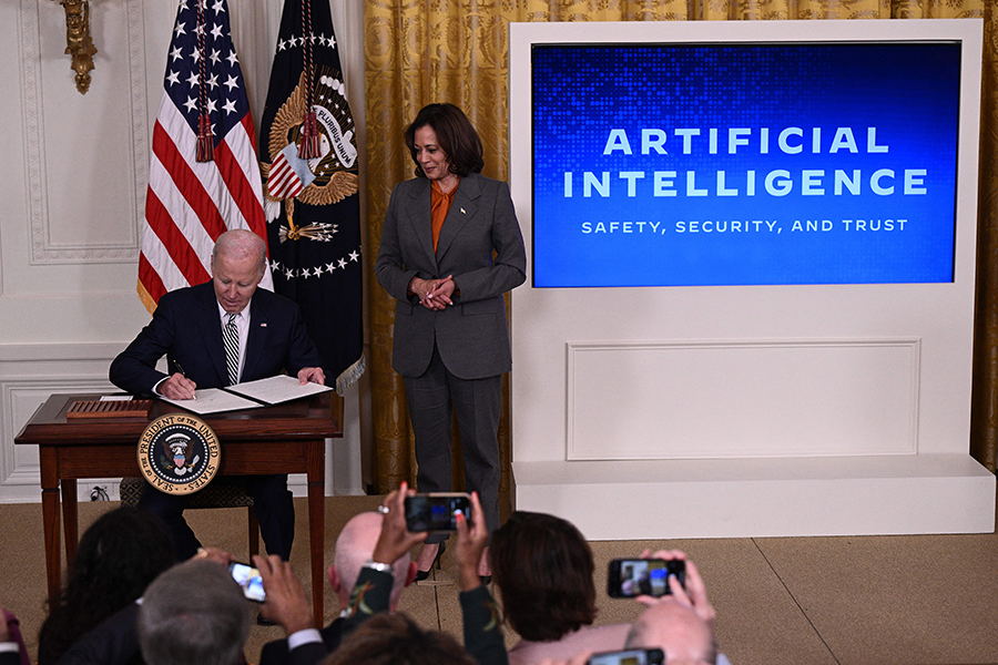 With Vice President Kamala Harris (R) looking on, U.S. President Joe Biden signs an executive order on advancing the safe, secure, and trustworthy development and use of artificial intelligence at the White House on October 30.  (Photo by Brendan Smialowski/AFP via Getty Images)